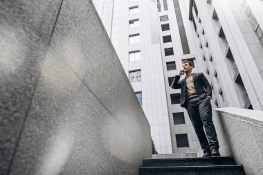 Şık giysiler içinde telefonda açık konuşuyor yakışıklı adam görüntüsünü