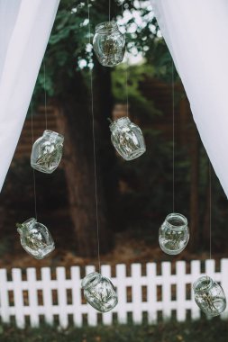 Orijinal düğün dekor. Küçük kavanozların bahçede iş parçacığı üzerinde asılı