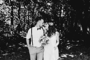 Genç bir damat güzel gelini kucaklar. Gülüyorlar