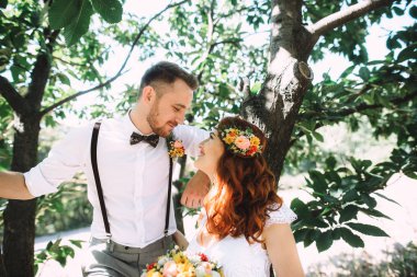 Onun güzel kızıl saçlı gelin ile damat büyük bir yeşil ağaç standları