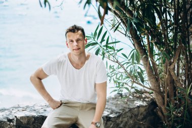 Mavi deniz arka plan üzerinde yakışıklı genç bir adam portresi