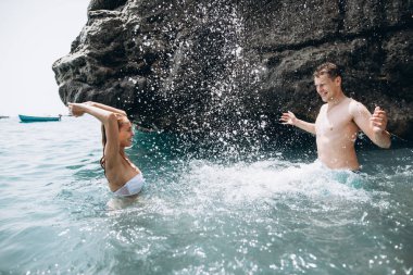 Adam ve kız denizde eğleniyorlar. Aşk hikayesi. İtalya