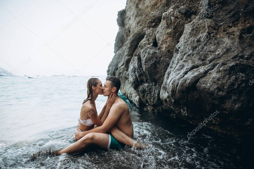 Couple kiss and hug in the sea. Love story. Italy
