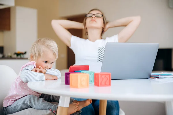 Young Mother Tired Working Laptop Her Little Daughter Sitting Next — Stock Photo, Image