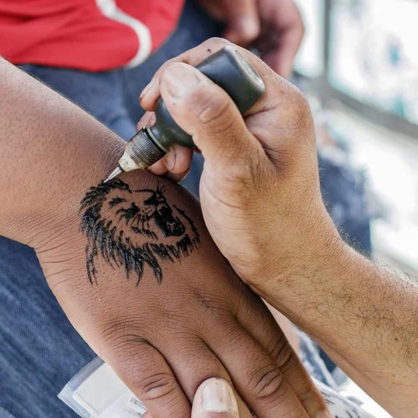 Maestro Del Tatuaje Aplica Tatuaje Henna Imagen De Stock