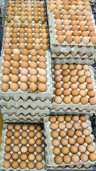 Karton kutulardaki tavuk yumurtaları raflarda.