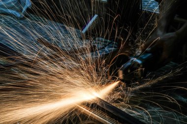  Öğütücüyle metal kesen bir işçi. Demir öğütürken kıvılcımlar