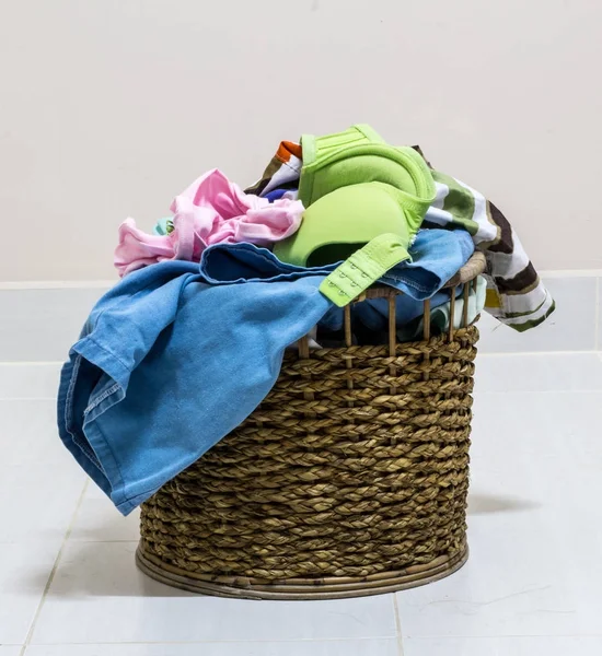 Pile of dirty laundry in a washing basket on a white background
