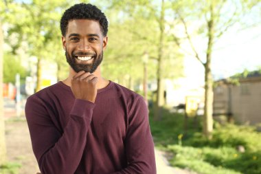 Siyah adam ayakta ve parkta poz