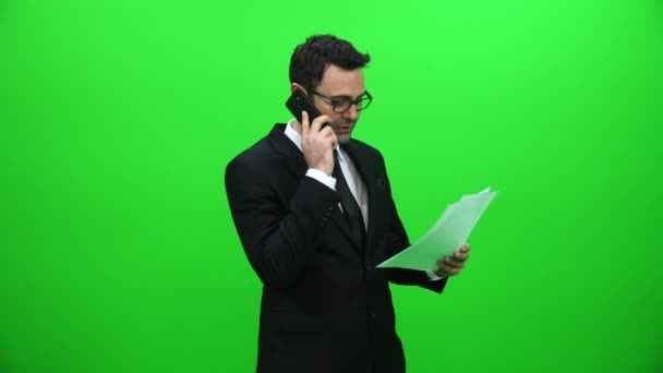 ビジネスマンの緑のスクリーン上で論文を押し電話で話して — ストック動画