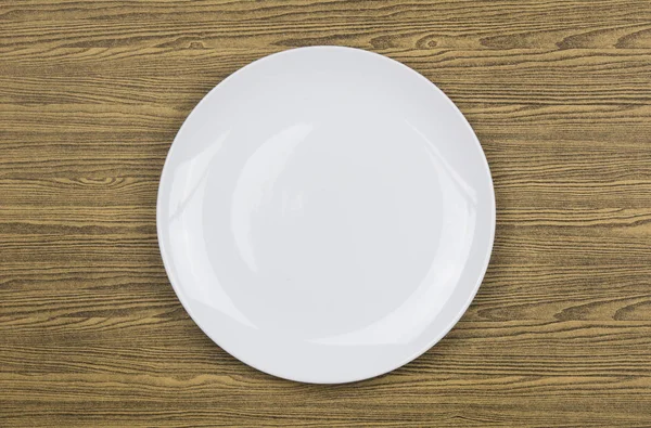 Top view of white plate on wood — Stock Photo, Image