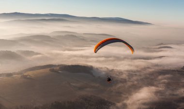 woman paramotor flying over the clouds clipart