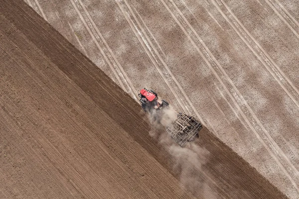 Трактор, що працює на полі врожаю — стокове фото