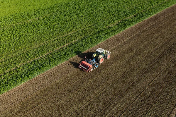 Aerial view of the tractor on the harvest field — Stock Photo, Image