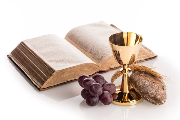composition with golden chalice, bread, bunch of grapes and Holy bible