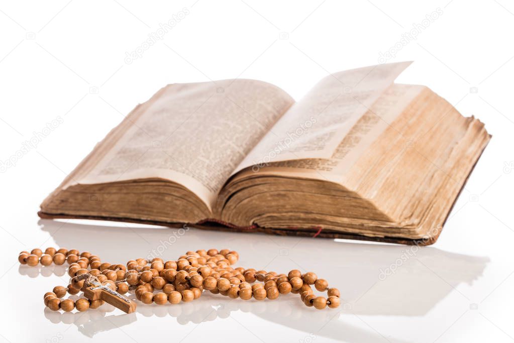 Christian composition with Holy Bible with wooden rosary near