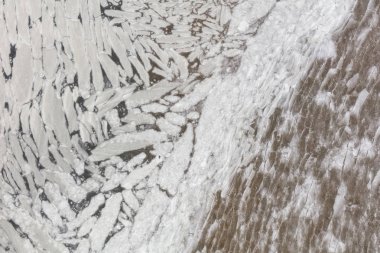 Sahilde buz erime havadan görünümü. Tuhaf desen buz blokları yeşil su.