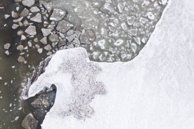 Sahilde buz erime havadan görünümü. Tuhaf desen buz blokları yeşil su.