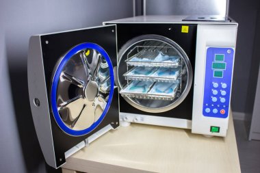 Otoklav, maşa manikür tıbbi bir otoklav arka plan üzerinde tıbbi aletleri sterilize