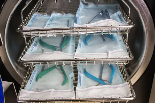 Otoklav, maşa manikür tıbbi bir otoklav arka plan üzerinde tıbbi aletleri sterilize