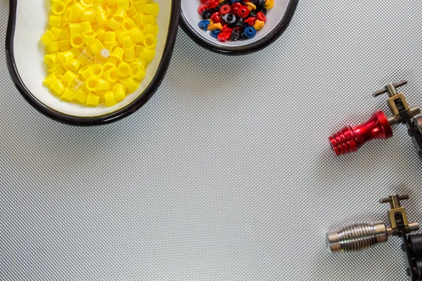 Tattoo Ink Caps and tattoo equipment in a kidney bowl