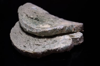 Siyah arka planda küflü beyaz ekmek. Siyah bir masada küflü ekmek dilimi