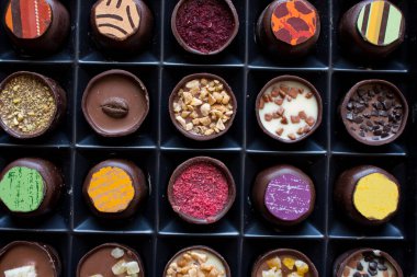 Çikolata ve cevizli şekerleme ile çeşitli tatlandırıcılar. El yapımı bir kutu çikolata. Gerçekçi çikolata seti, lezzetli tatlı deseni..