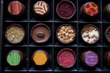 Çikolata ve cevizli şekerleme ile çeşitli tatlandırıcılar. El yapımı bir kutu çikolata. Gerçekçi çikolata seti, lezzetli tatlı deseni..