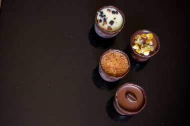 Çikolata ve cevizli şekerleme ile çeşitli tatlandırıcılar. El yapımı bir kutu çikolata. Gerçekçi çikolata seti, lezzetli tatlı deseni..