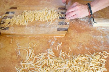 Makarnalar mutfağın iç kısımlarına yakın çekim yapıyor. Pişirme işlemi, unlu çiğ makarna.