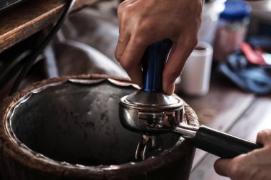 Barista kahve yapmak için dış müdahale tarafından portafilter çekilmiş kahve basarak