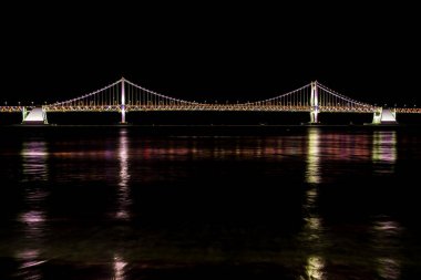 Busan, Güney Kore - 31 Aralık 2019 Busan Gwangan köprüsü gece vakti Gwangalli plajından alındı.