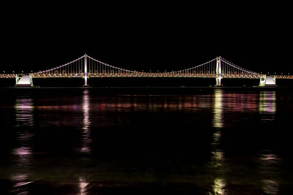 Busan, Güney Kore - 31 Aralık 2019 Busan Gwangan köprüsü gece vakti Gwangalli plajından alındı.
