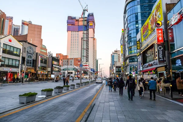 Busan, Güney Kore - 3 Nisan 2019: Akşamları Haeundae plajı boyunca yürüyen turist. Haeundae Mahallesi)