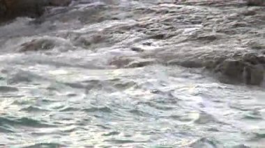 Köpük ile taş plajda sörf