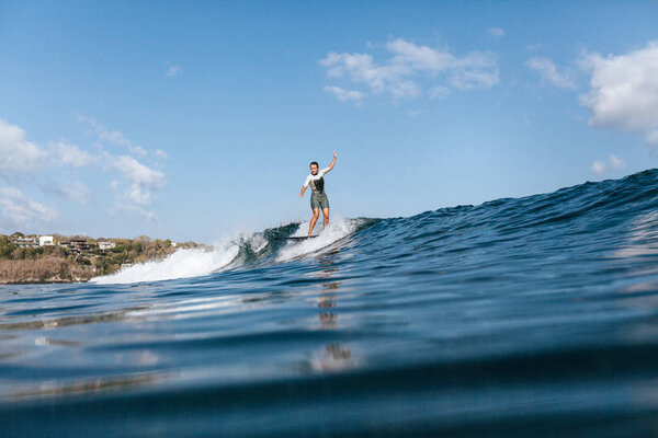 girl riding wave on surf board in ocean