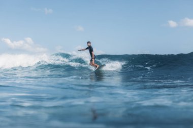sportsman surfing wave on board in ocean  clipart