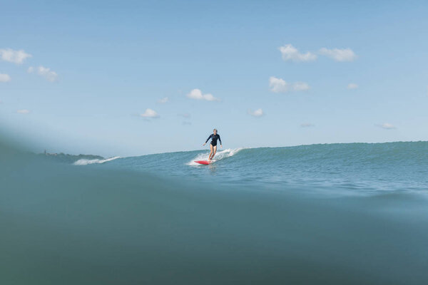 female surfer riding wave on surf board in ocean
