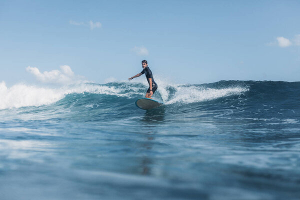 sportsman surfing wave on surf board in ocean 