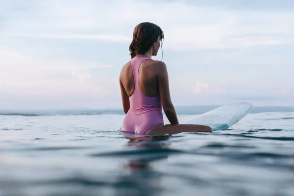 Visão Traseira Jovem Esportista Sentada Prancha Surf Água — Fotografia de Stock Grátis