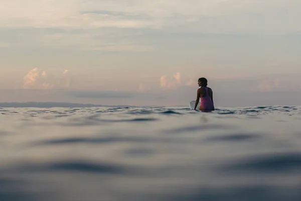 冲浪者的剪影坐在冲浪板在水在日落 — 图库照片