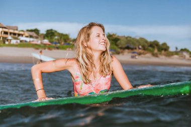 sörf tahtası ile takım elbise okyanusta yüzmeye içinde genç bir kadın portresi