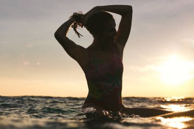 sunset bulvarında okyanus sörf gemide otururken... saç dolayı kadın silüeti