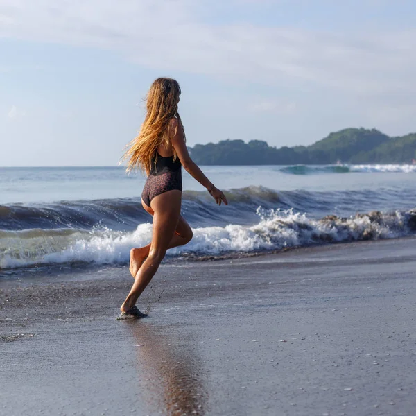 Młoda Kobieta Działa Tropikalnej Plaży Pobliżu Oceanu — Zdjęcie stockowe