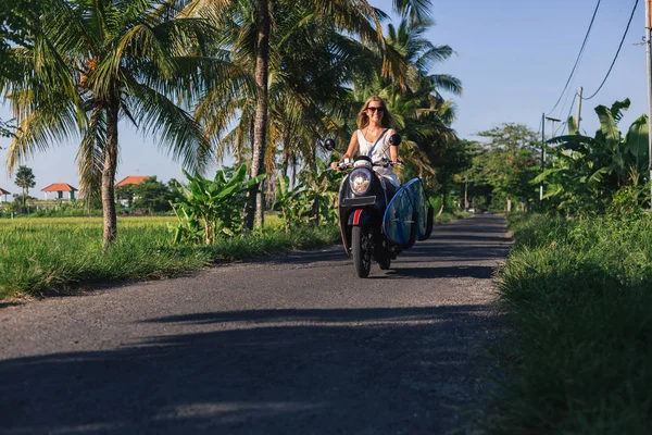 Joven Mujer Montando Scooter Con Tabla Surf — Foto de Stock