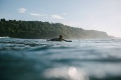fiatal férfi úszás, a szörf napsütéses napon