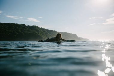 yakışıklı adam sörf tahtası üzerinde güneşli günde Yüzme