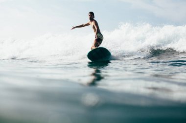 Dalgalar sörf tahtası üzerinde tatil yaparken yakışıklı kişini