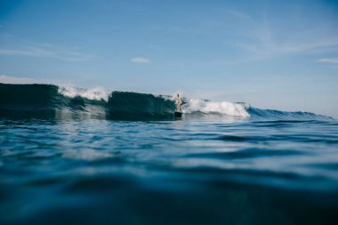 Genç sporcunun dalgalar sörf tahtası üzerinde sürme