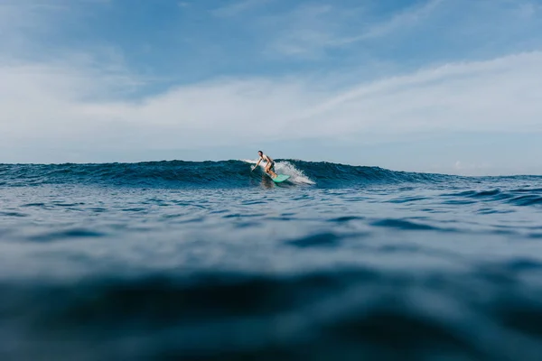 Schöner Mann Der Blaue Meereswellen Auf Einem Surfbrett Reitet — kostenloses Stockfoto